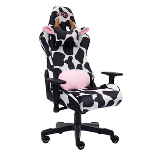 The original cow gaming chair by techni sport shown against a white background at an angle. The cow gaming chair has the lumbar pillow flipped around to show that it is reversible with black and white print on one side and fluffy pink material on the other. The cow gaming chair also features a black base, wheels and hardware. The original cow gaming chair also has a headrest with light brown horns and cute ears with a fluffy pink lining The materials used are velvet for the ultimate softness. 