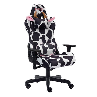 The original cow gaming chair by techni sport shown against a white background at an angle. The cow gaming chair has the lumbar pillow flipped around to show that it is reversible with black and white print on the front side and fluffy pink material on the other. The cow gaming chair also features a black base, wheels and hardware. The original cow gaming chair also has a headrest with light brown horns and cute ears with a fluffy pink lining The materials used are velvet for the ultimate softness. 